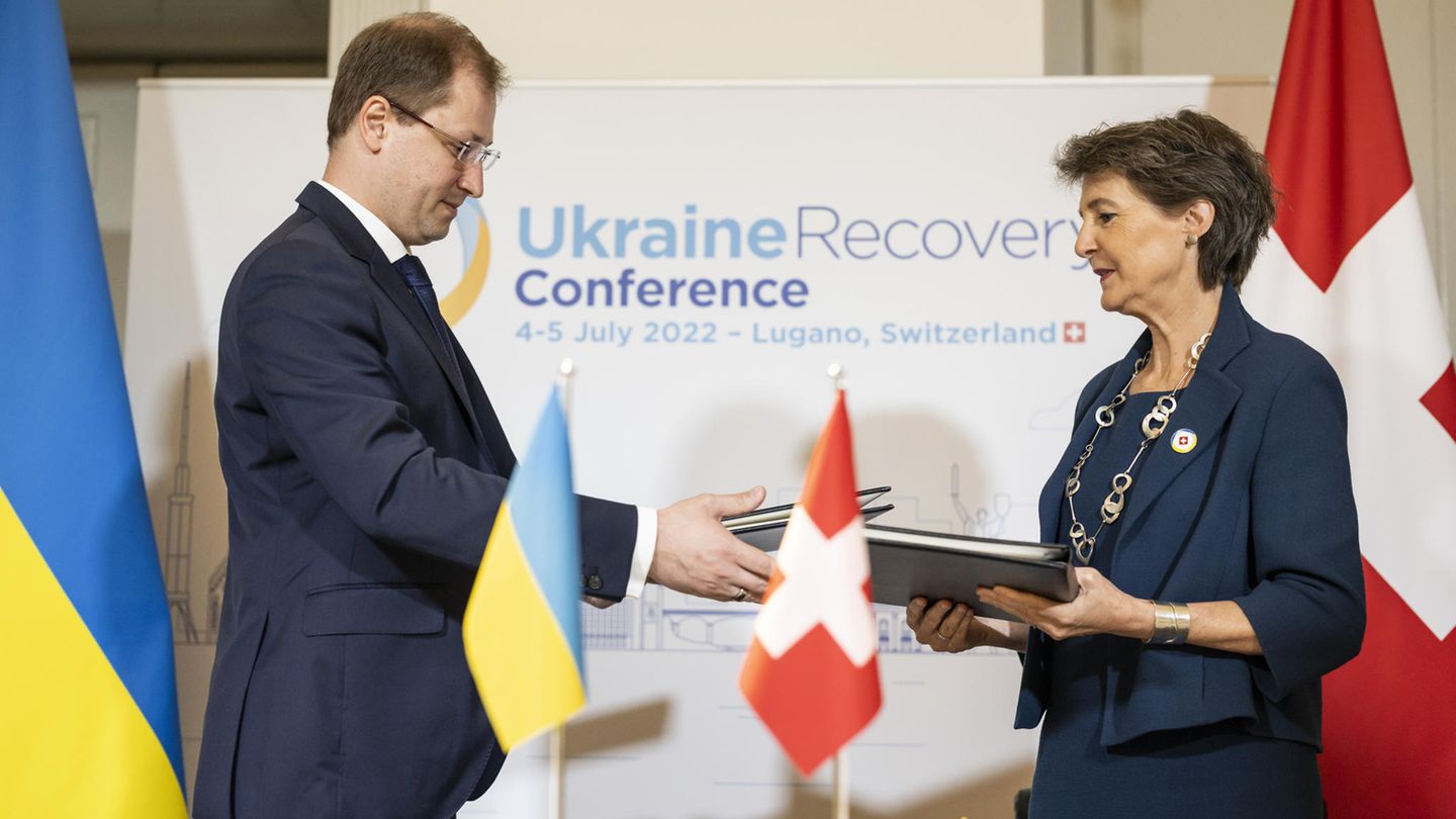 Verkehs- und Umweltministerin Simonetta Sommaruga und der ukrainische Minister für Ökologie, Ruslan Strilets, tauschen Dokumente bei der Recovery Conference URC aus, um den politischen Prozess für die Erholung der Ukraine nach dem Angriff Russlands auf ihr Territorium einzuleiten