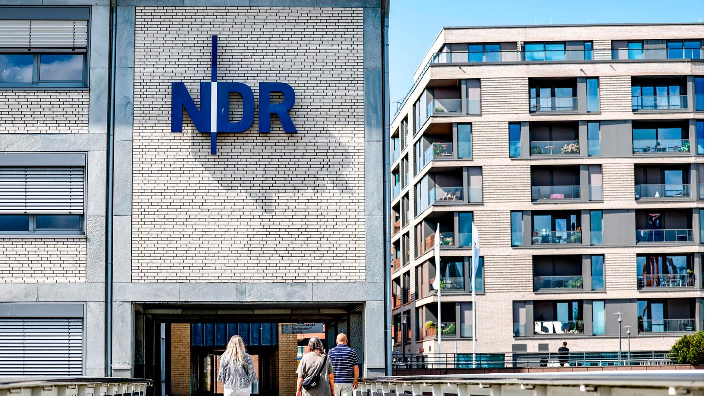Schleswig-Holstein, Kiel: Passanten gehen vor der Einfahrt zum Landesfunkhaus Schleswig-Holstein des NDR entlang