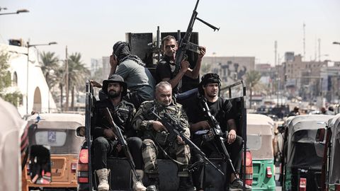 Irak, Bagdad: Bewaffnete Mitglieder von Saraya al-Salam ("Friedenskompanie"), dem militärischen Flügel des schiitischen Geistlichen Al-Sadr, fahren in einem Fahrzeug während Zusammenstößen mit irakischen Sicherheitskräften in der Grünen Zone