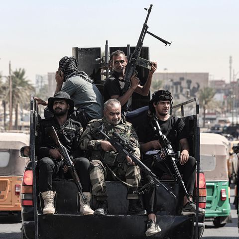Irak, Bagdad: Bewaffnete Mitglieder von Saraya al-Salam ("Friedenskompanie"), dem militärischen Flügel des schiitischen Geistlichen Al-Sadr, fahren in einem Fahrzeug während Zusammenstößen mit irakischen Sicherheitskräften in der Grünen Zone