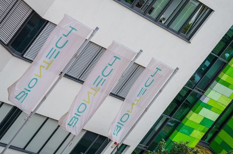 Fahnen mit Biontech-Logo wehen vor dem Hauptsitz des Unternehmens in Mainz