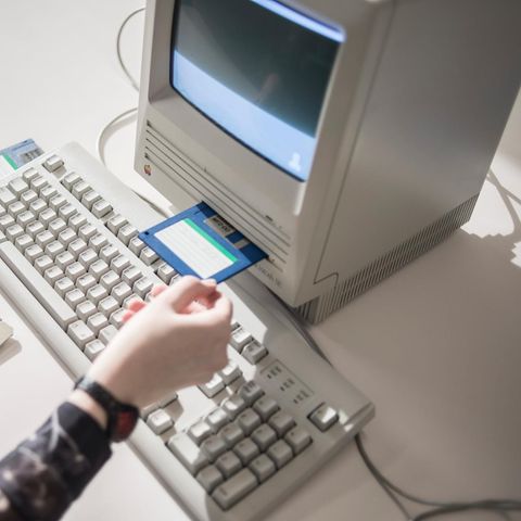 Japan: Ein Frau schiebt eine Diskette in einen alten Computer