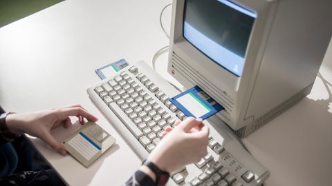 Japan: Ein Frau schiebt eine Diskette in einen alten Computer