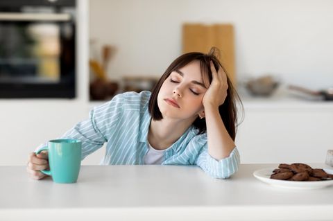 Frau ist müde und trinkte Kaffee