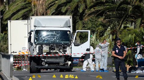 Polizisten stehen um den Lastwagen, mit dem der Attentäter beim Anschlag in Nizza in eine Menschenmenge gerast war