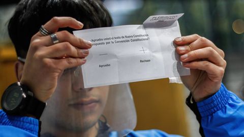 Ein Wahlhelfer in der Hafenstadt Valparaiso in Chile zeigt einen Stimmzettel, auf dem "Ablehnung" angekreuzt ist.
