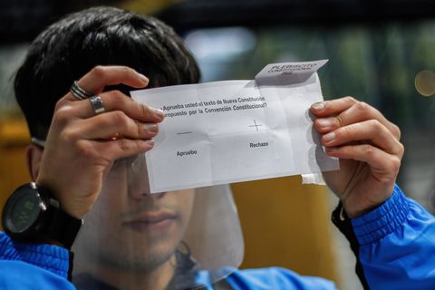 Ein Wahlhelfer in der Hafenstadt Valparaiso in Chile zeigt einen Stimmzettel, auf dem "Ablehnung" angekreuzt ist.