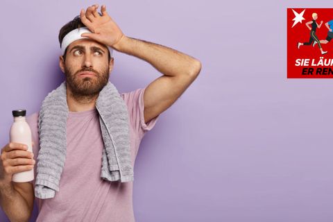 Ein Sportler mit Trinkflasche wischt sich über die Stirn