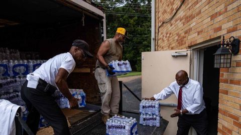 Mitglieder der Progressive Morningstar Baptist Church transportieren Kisten mit Wasser