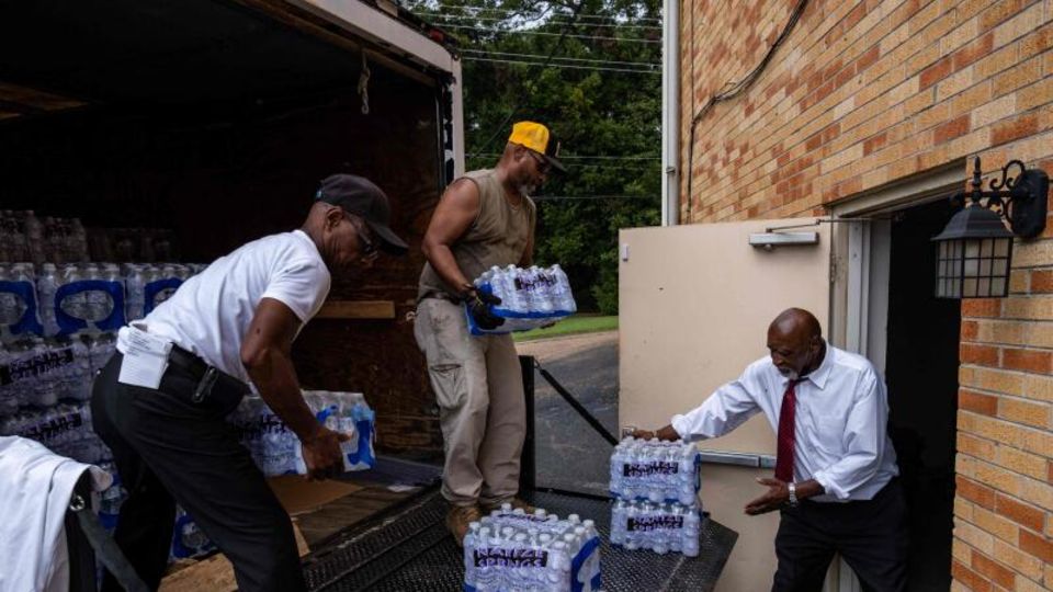 Mitglieder der Progressive Morningstar Baptist Church transportieren Kisten mit Wasser