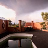 Ferienhaus vor rauchendem Vulkan