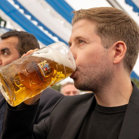 Kevin Kühnert trinkt Bier aus einem Maßkrug