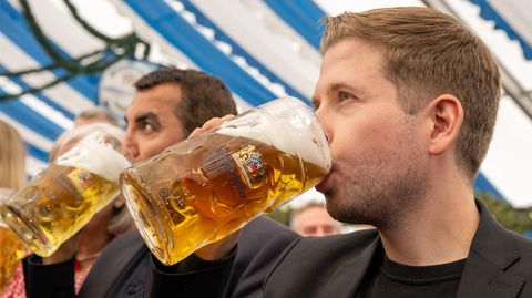 Kevin Kühnert trinkt Bier aus einem Maßkrug