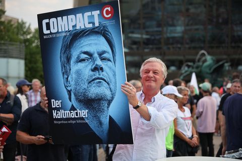 Jürgen Elsässer hält ein Bild mit Habeck in die Höhe