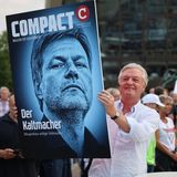 Jürgen Elsässer hält ein Bild mit Habeck in die Höhe