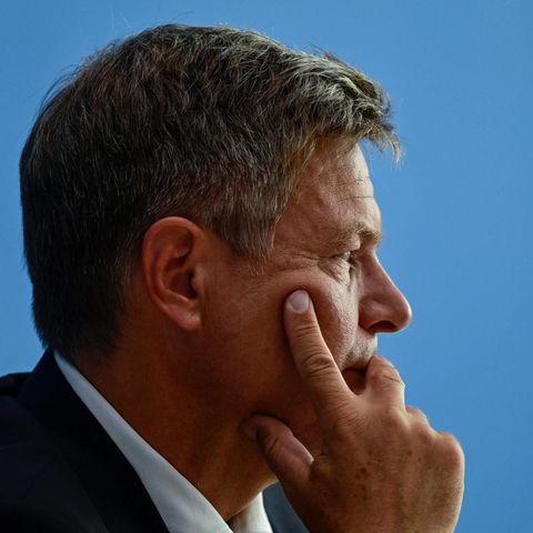 Ein Mann im Anzug sitzt im Gegenlicht und ist im Profil zu sehen