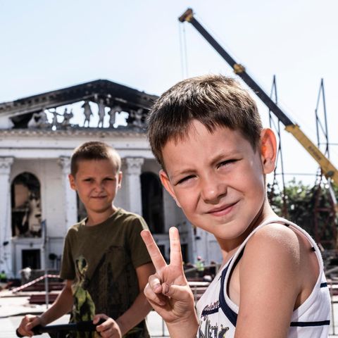 Zwei Jungen spielen vor einem zerstörten Theater