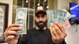 Ein Mann hält einen US-Dollar-Schein in der einen und mehrere Noten des Libanesischen Pfund in der anderen Hand
