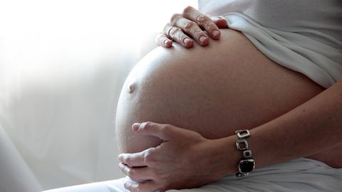 Eine Frau hält ihren schwangeren Bauch