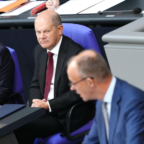 Bundeskanzler Olaf Scholz (M., SPD) und Oppositionsführer Friedrich Merz (r., CDU)