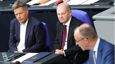 Bundeskanzler Olaf Scholz (M., SPD) und Oppositionsführer Friedrich Merz (r., CDU)