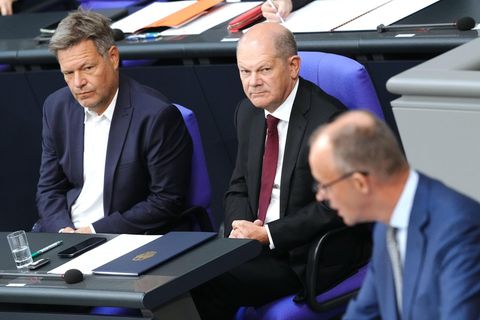 Bundeskanzler Olaf Scholz (M., SPD) und Oppositionsführer Friedrich Merz (r., CDU)
