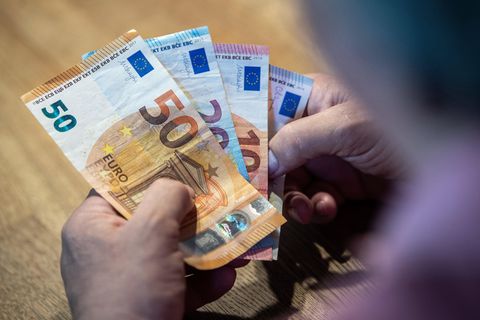 Mehrere Euro-Scheine liegen in einer Hand, die Person zählt das Geld. Symbolfoto für Thema zur Mittelschicht.