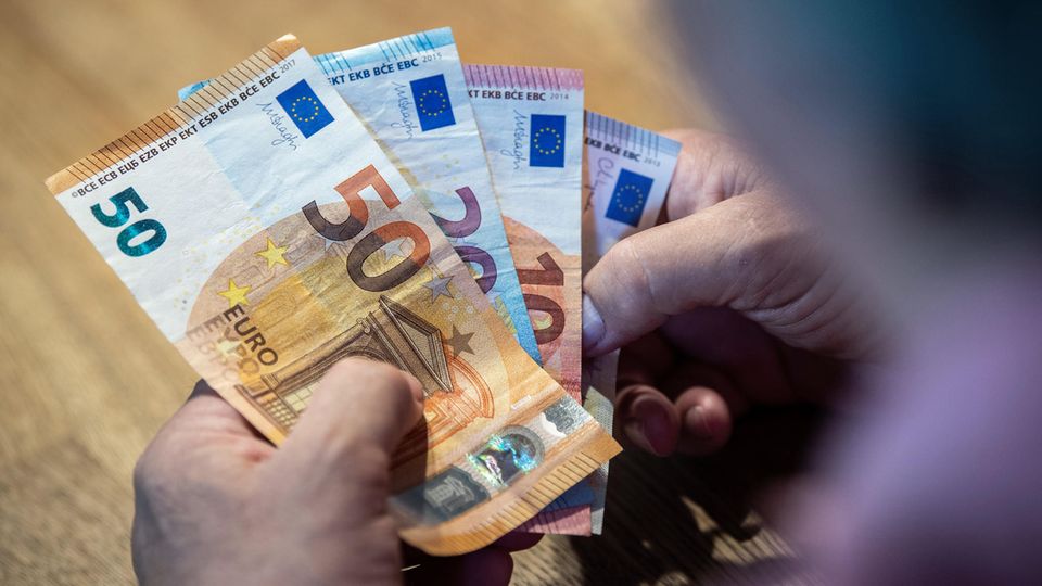 Mehrere Euro-Scheine liegen in einer Hand, die Person zählt das Geld. Symbolfoto für Thema zur Mittelschicht.