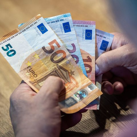 Mehrere Euro-Scheine liegen in einer Hand, die Person zählt das Geld. Symbolfoto für Thema zur Mittelschicht.