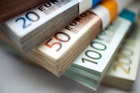 Euroscheine liegen gestapelt und aufgefächert übereinander