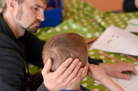 Ein Betreuer tröstet einen Jungen in der Arche in Berlin-Hellersdorf. Die Einrichtungen der Arche kümmern sich etwa mit Hausaufgabenhilfe besonders um Kinder aus bedürftigen Familien
