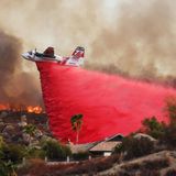 Ein Löschflugzeugen versucht, Häuser an einem Hügel bei Hemet vor den Flammen zu bewahren