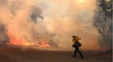 Ein Feuerwehrmann kämpft gegen das anstürmende Fairview-Feuer