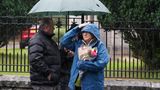 Die Briten harren im Regen aus und haben Blumen und kleine Schilder mit netten Botschaften an ihre Queen dabei.