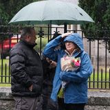 Die Briten harren im Regen aus und haben Blumen und kleine Schilder mit netten Botschaften an ihre Queen dabei.