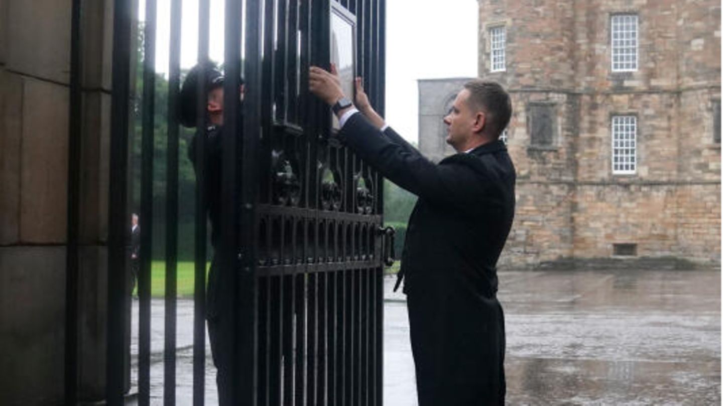 Queen Elizabeth II.: Ein angestellter des Buckingham Palastes hängt die Nachricht über den Tod der Queen an die Tore des Palastes. Ein angestellter des Buckingham Palastes hängt die Nachricht über den Tod der Queen an die Tore des Palastes.