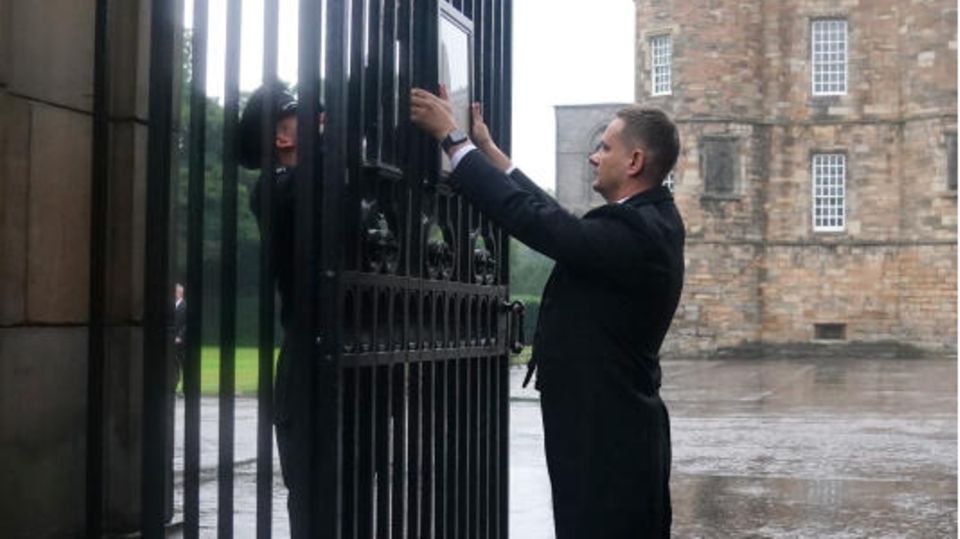 Queen Elizabeth II.: Ein angestellter des Buckingham Palastes hängt die Nachricht über den Tod der Queen an die Tore des Palastes. Ein angestellter des Buckingham Palastes hängt die Nachricht über den Tod der Queen an die Tore des Palastes.