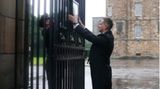 Ein angestellter des Buckingham Palastes hängt die Nachricht über den Tod der Queen an die Tore des Palastes. 