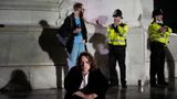 Ein junger Mann sitzt auf den Stufen vor dem Buckingham Palace