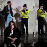 Ein junger Mann sitzt auf den Stufen vor dem Buckingham Palace