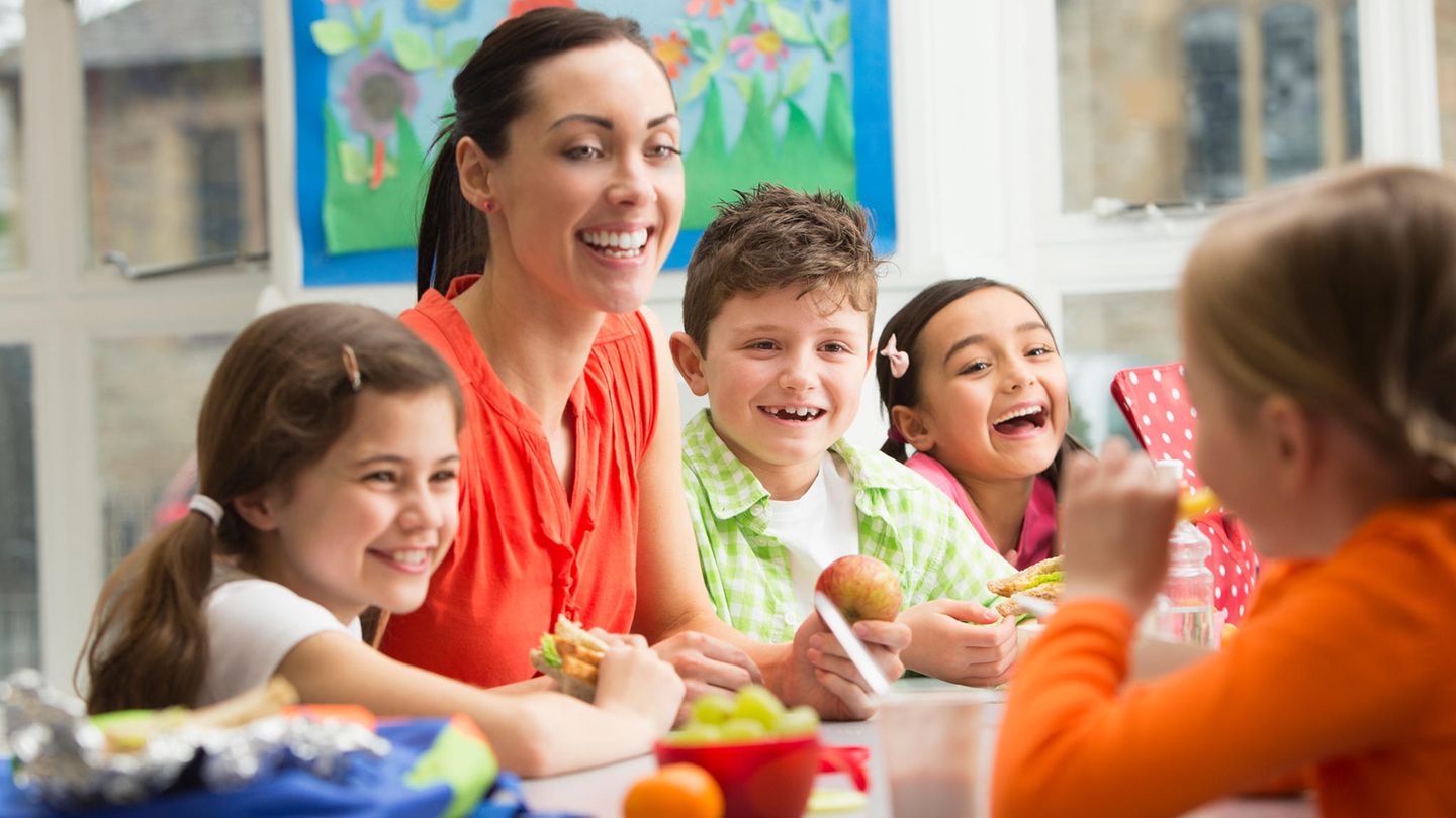Eine Lehrerin betreut Grundschulkinder während der Pause