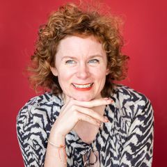 Tina Molin, eine Frau mit Locken, stützt den Kopf auf ihrer Hand ab