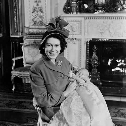 Queen Elizabeth II. sitzt mit ihrem ersten Sohn Prince Charles Philip Arthur George auf einem Stuhl.