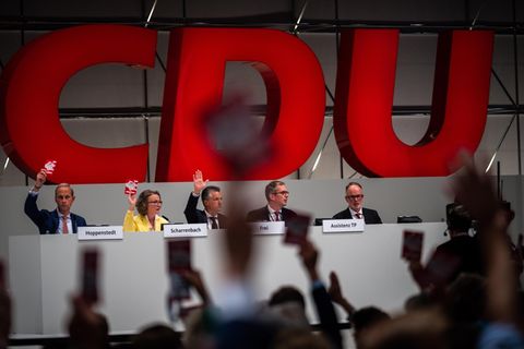 Delegierte halten beim CDU Bundesparteitag ihre Stimmkarte hoch