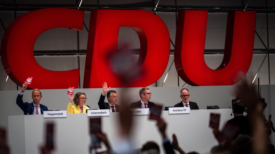 Delegierte halten beim CDU Bundesparteitag ihre Stimmkarte hoch