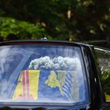 Der Sarg ist eingehüllt mit der schottischen königlichen Standarte. Darauf liegt ein Kranz aus Dahlien, Flammenblumen, Heidekraut, Duftwicken, Strandflieder und Kiefer, die allesamt aus den Gärten des schottischen Anwesens stammen.