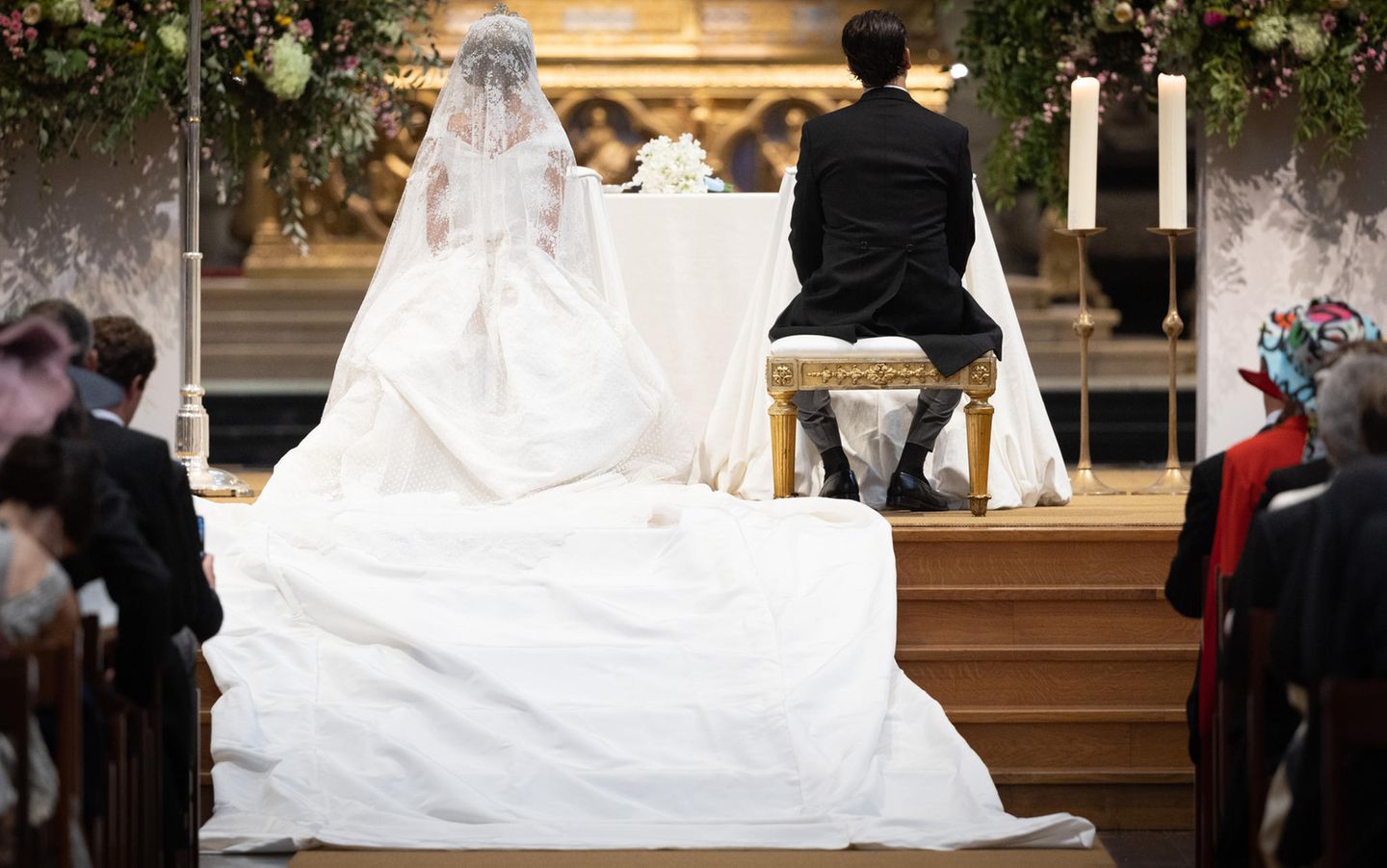 Prinzessin Maria Laura von Belgien sitzt mit ihrer langen Schleppe mit William Isvy vor dem Altar