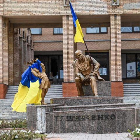 Ukrainische Flaggen auf Statuen auf einem Platz in Balaklija