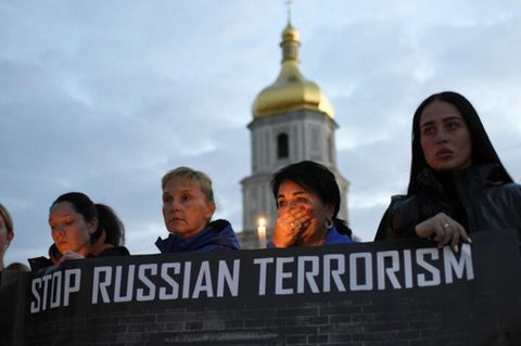 Ukraine: Frauen halten Banner mit der Aufschrift "Stoppt Russlands Terror" hoch
