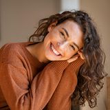 Eine Frau lacht glücklich in die Kamera.